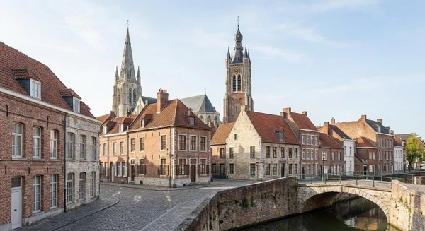 Photographie d'une vue caractéristique et reconnaissable de Saint-Omer, montrant son architecture typique du Nord (cathédrale, beffroi, maisons traditionnelles flamandes ou bâtiments historiques du centre-ville), prise en conditions naturelles de jour. L'image doit transmettre le caractère local, patrimonial et la localisation géographique de Saint-Omer sans montrer de personnes ni d'activité de menuiserie, de manière à illustrer le contexte urbain dans lequel intervient l'Atelier des Menuisiers.