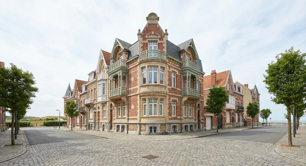 Photographie d'une rue caractéristique ou d'un bâtiment emblématique de Malo-les-Bains, montrant l'architecture typique de cette station balnéaire côtière du Nord. L'image doit transmettre le caractère local et la localisation géographique, sans montrer de personnes ni d'activité de menuiserie. Preferably une vue urbaine ou architecturale reconnaissable de Malo-les-Bains en conditions naturelles.