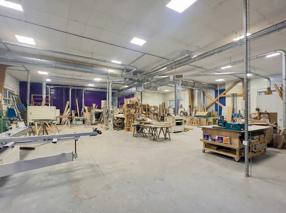Artisan menuisier travaillant dans son atelier, mesurant et marquant des planches de bois avec un crayon
