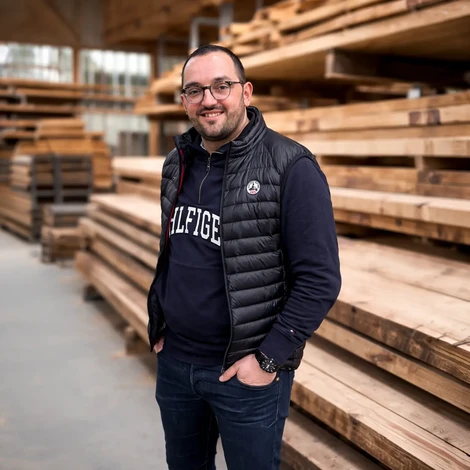 Atelier de menuiserie avec artisan concentré travaillant sur établi, portant protection auditive